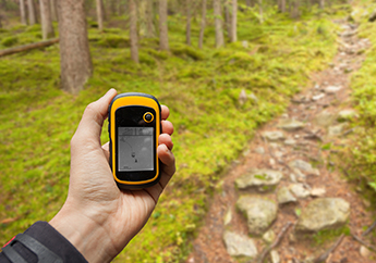 Person holding GPS equipment in order to search for geocache in a MoStatePark 